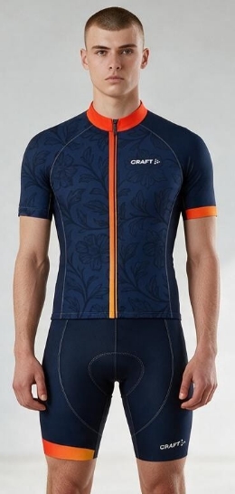 A person wearing a navy cycling jersey and shorts with orange accents from Craft.