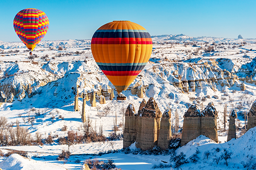 twee luchtballon boven besneeuwd cappadocië in de winter