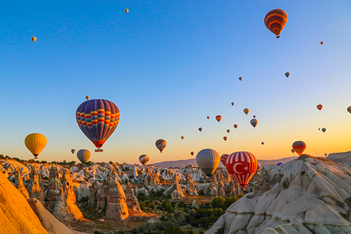 uitzicht op cappadocië vanuit een luchtballon in de lucht met veel andere ballonnen op de achtergrond