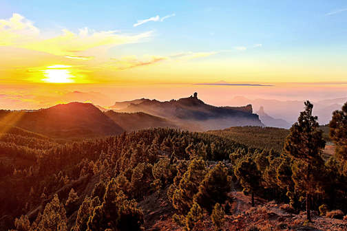 Zonsondergang bij Pico de las Nieves met uitzicht over beboste bergen, wolken en omliggende bergtoppen.