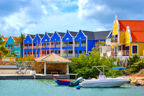 Kralendijk op Bonaire met kleurrijke gebouwen langs de boulevard, palmbomen en helderblauw water aan de kust