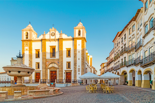 Romeinse tempel van Évora in Portugal met hoge stenen zuilen, historische gebouwen en een plein in het oude centrum.
