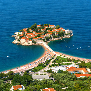 Eiland Sveti Stefan met oranje daken, verbonden met het strand door een smalle landtong.